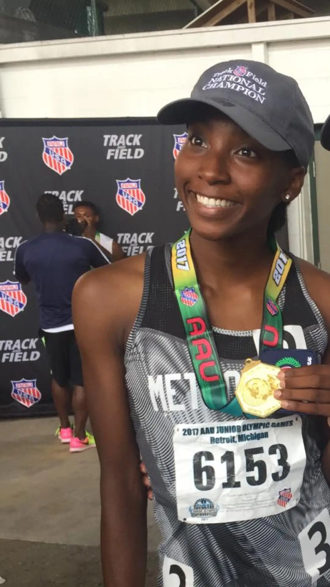 Vinnelle Grant in a Metropolis uniform holding an AAU national championship medal.
