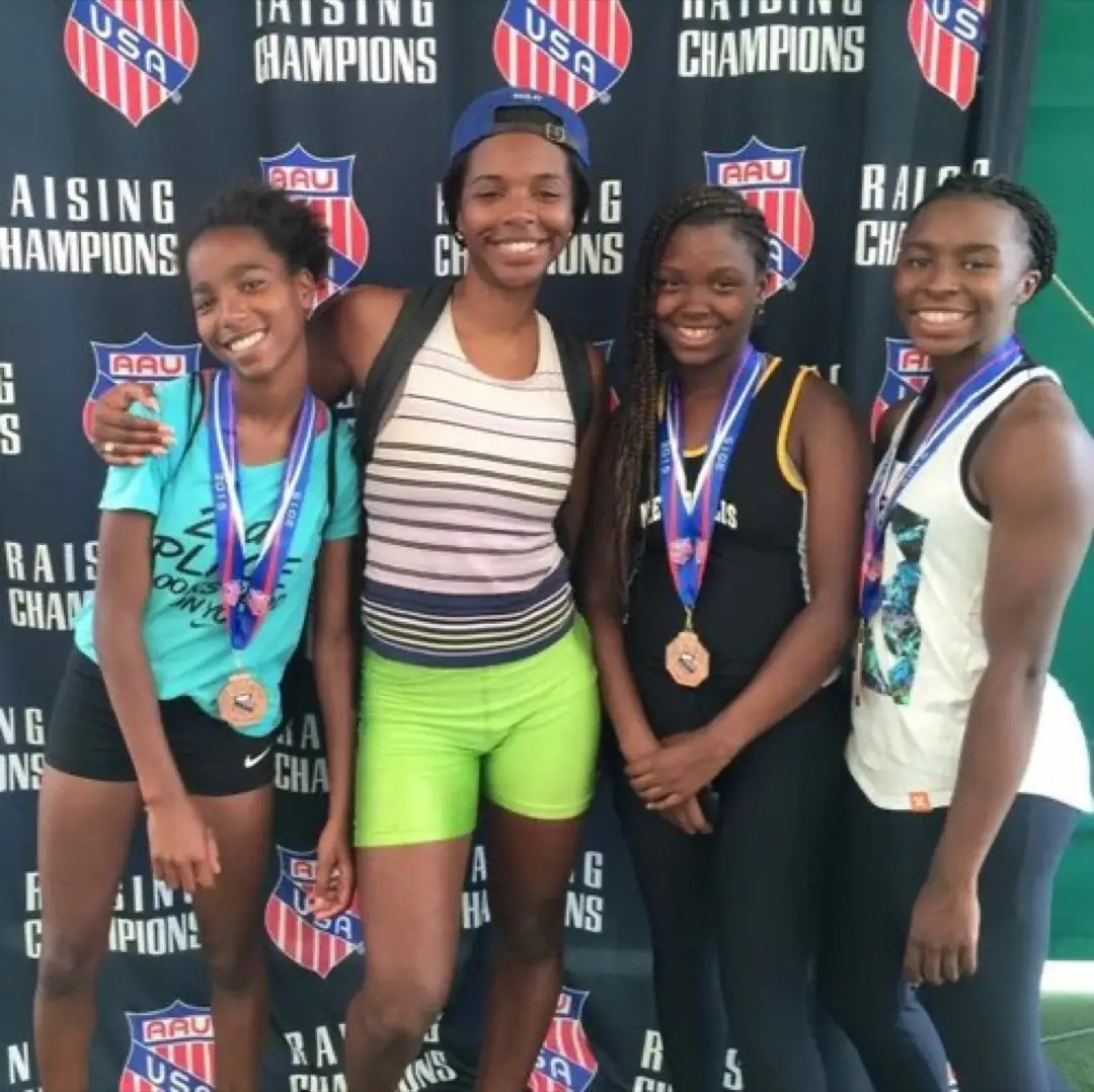 Coach Caprice Church with Metropolis athletes wearing medals at the 2016 AAU National Championship.